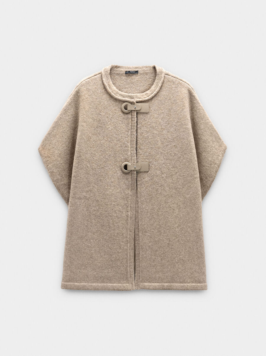 Knit poncho with buckles