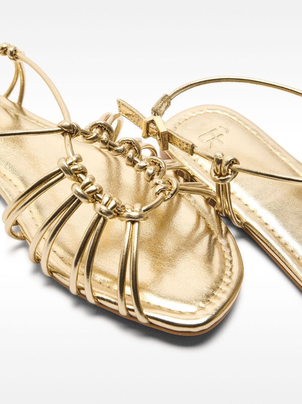 Metallic flat sandals with straps and knots